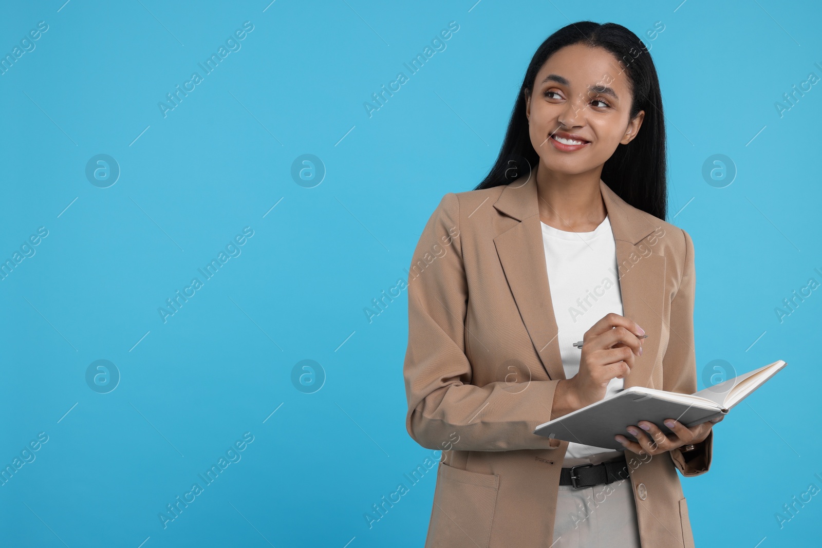 Photo of Beautiful secretary with notebook and pen on light blue background, space for text