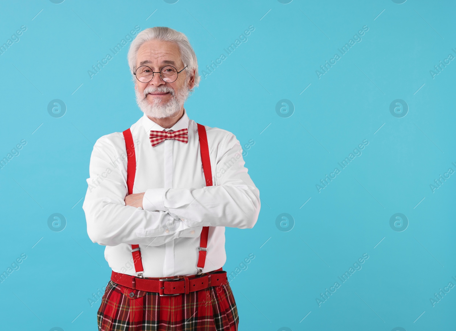 Photo of Portrait of stylish grandpa with glasses and bowtie on light blue background, space for text