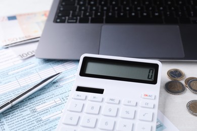 Tax accounting. Calculator, money, pen, document and laptop on light grey table, closeup