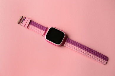 Photo of Trendy smart watch for kids on pink background, top view