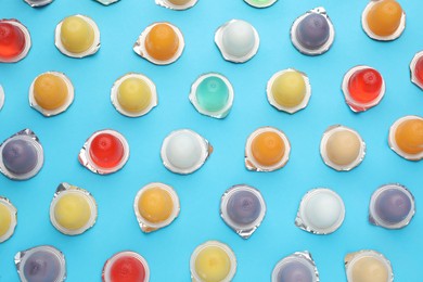 Photo of Tasty bright jelly cups on light blue background, flat lay