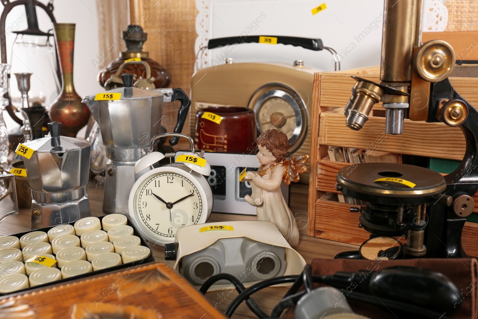 Photo of Many different items on wooden table indoors. Garage sale