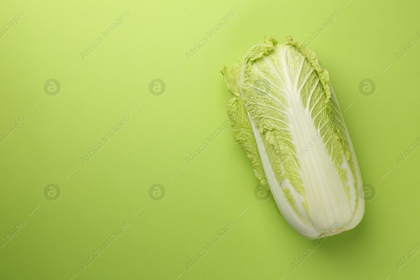 Photo of Fresh ripe Chinese cabbage on light green background, top view. Space for text