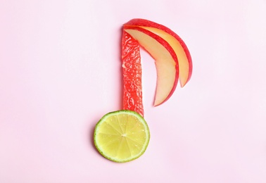 Musical note made of fruits on color background, top view