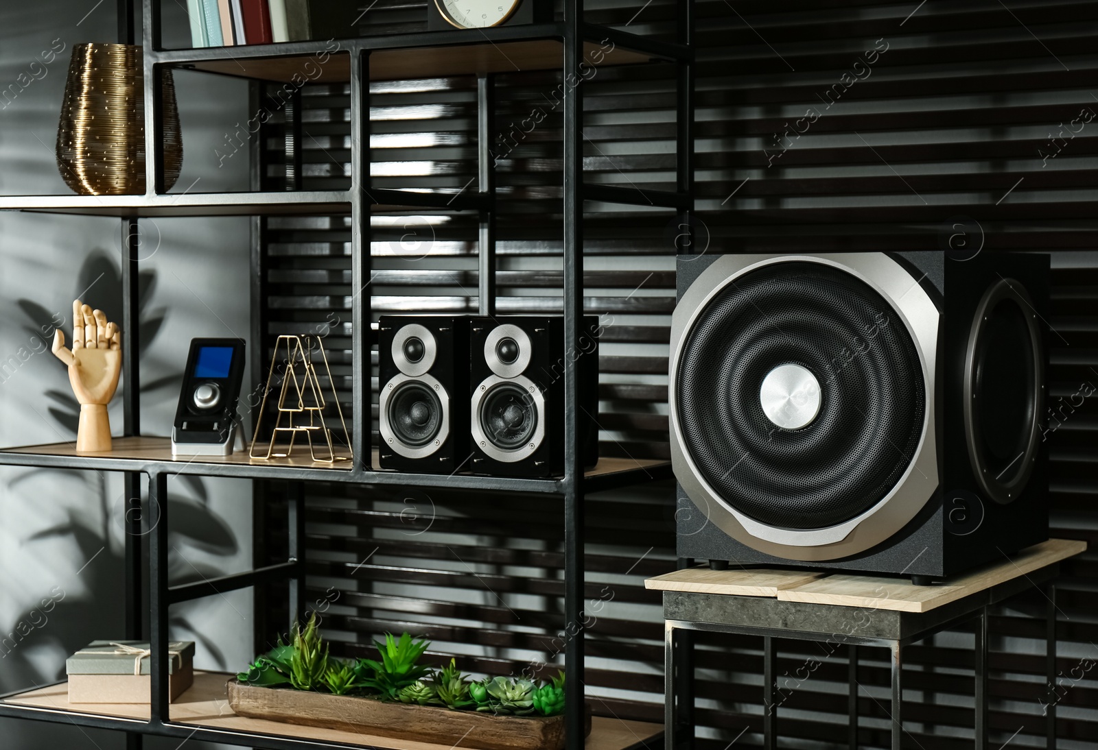 Photo of Modern audio speaker system on shelving indoors