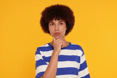 Photo of Portrait of thoughtful young woman on orange background