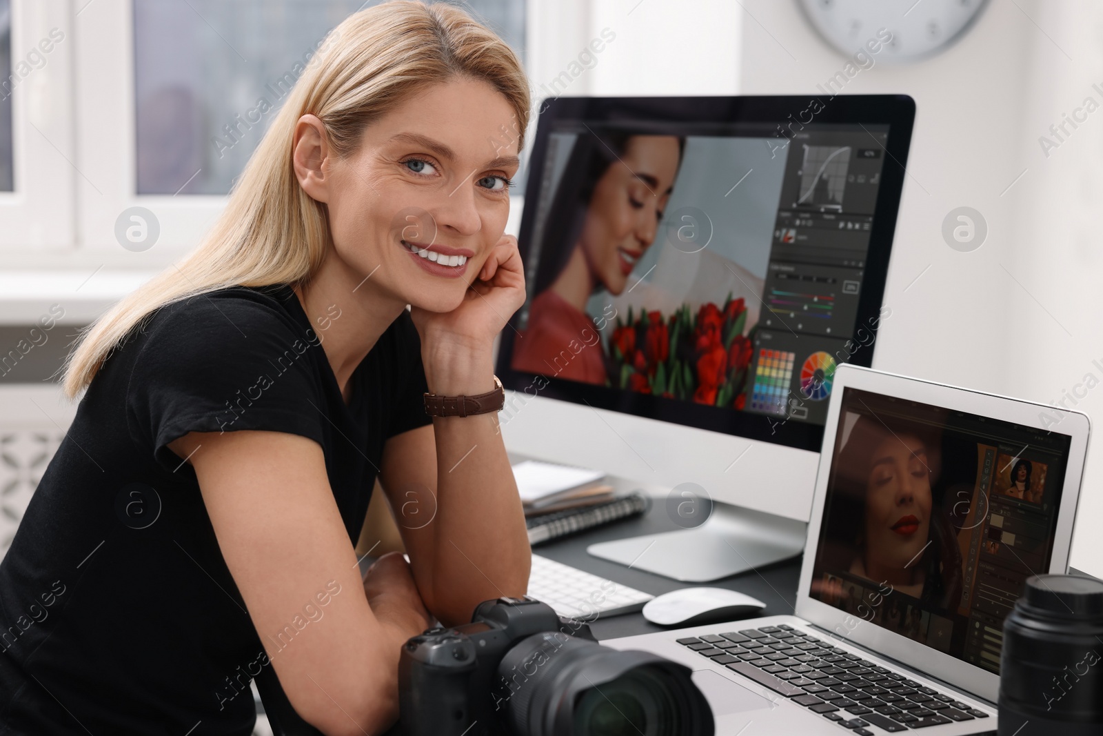 Photo of Professional photographer with digital camera at table in office