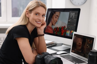 Photo of Professional photographer with digital camera at table in office