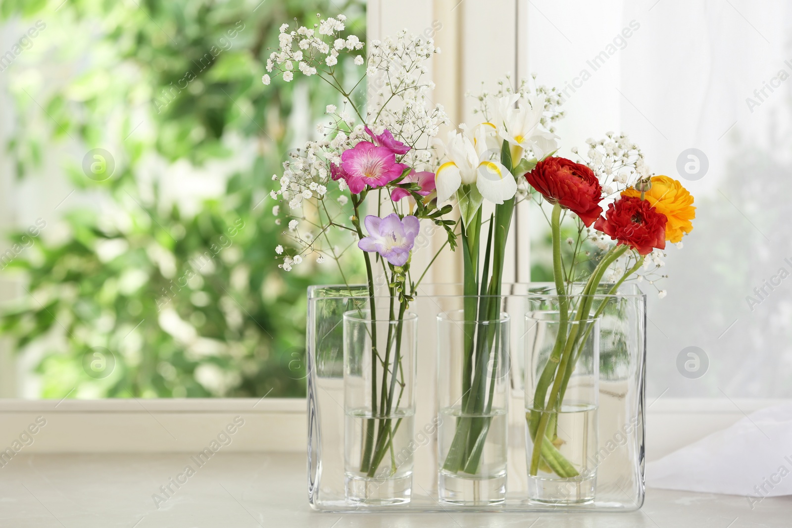 Photo of Beautiful fresh flowers on window sill indoors. Space for text