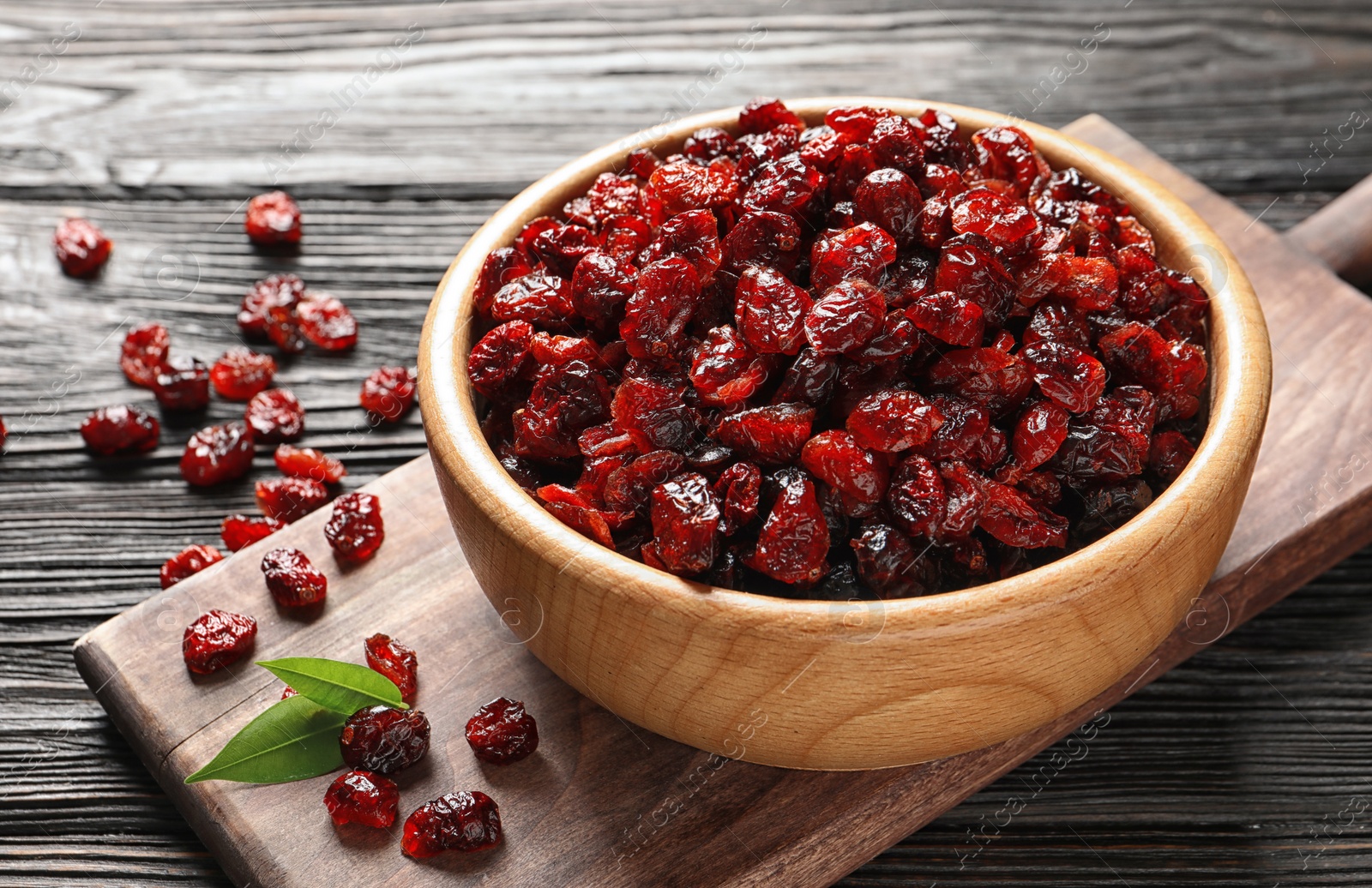 Photo of Bowl with cranberries on wooden table. Dried fruit as healthy snack