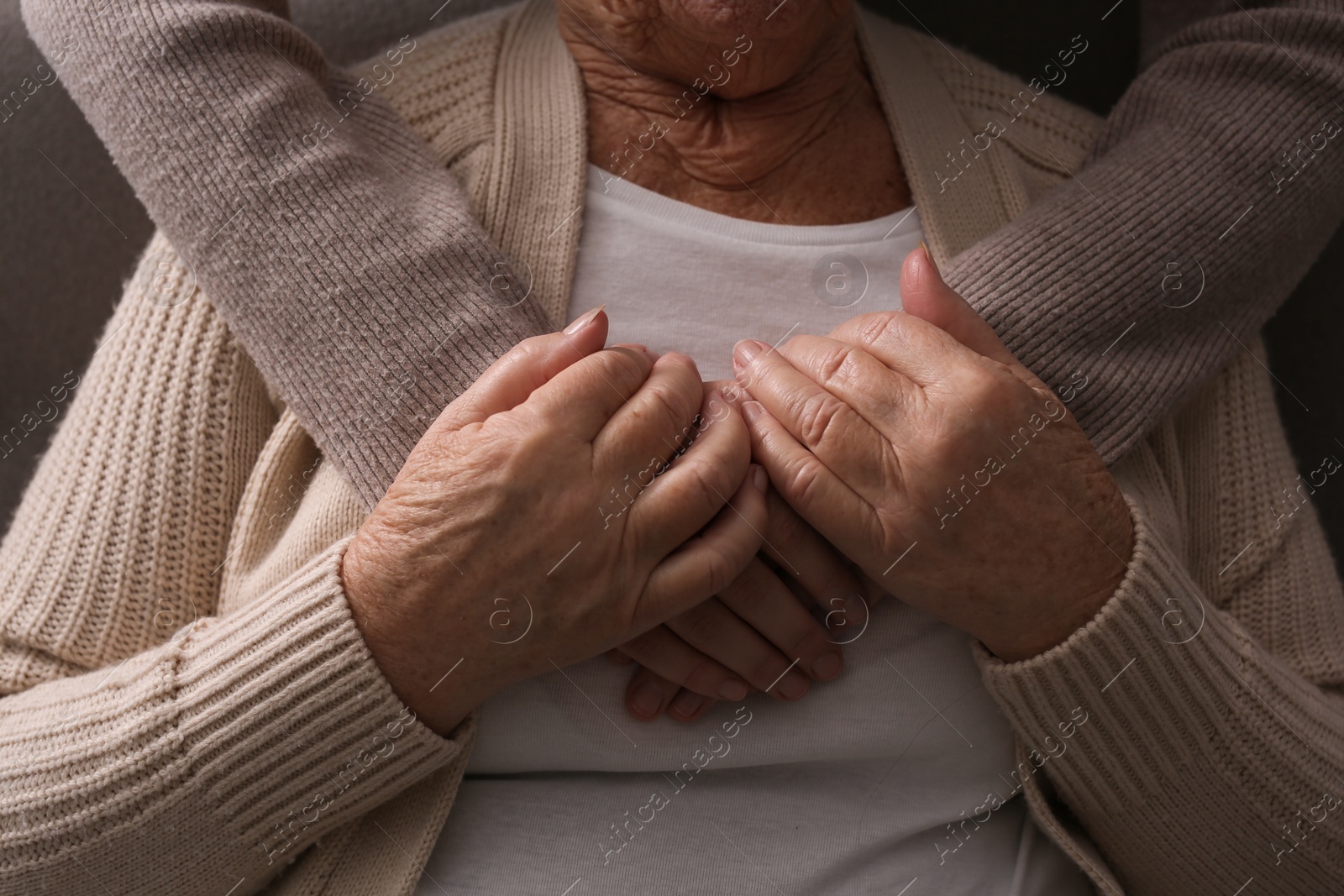 Photo of Young and elderly women hugging, closeup view