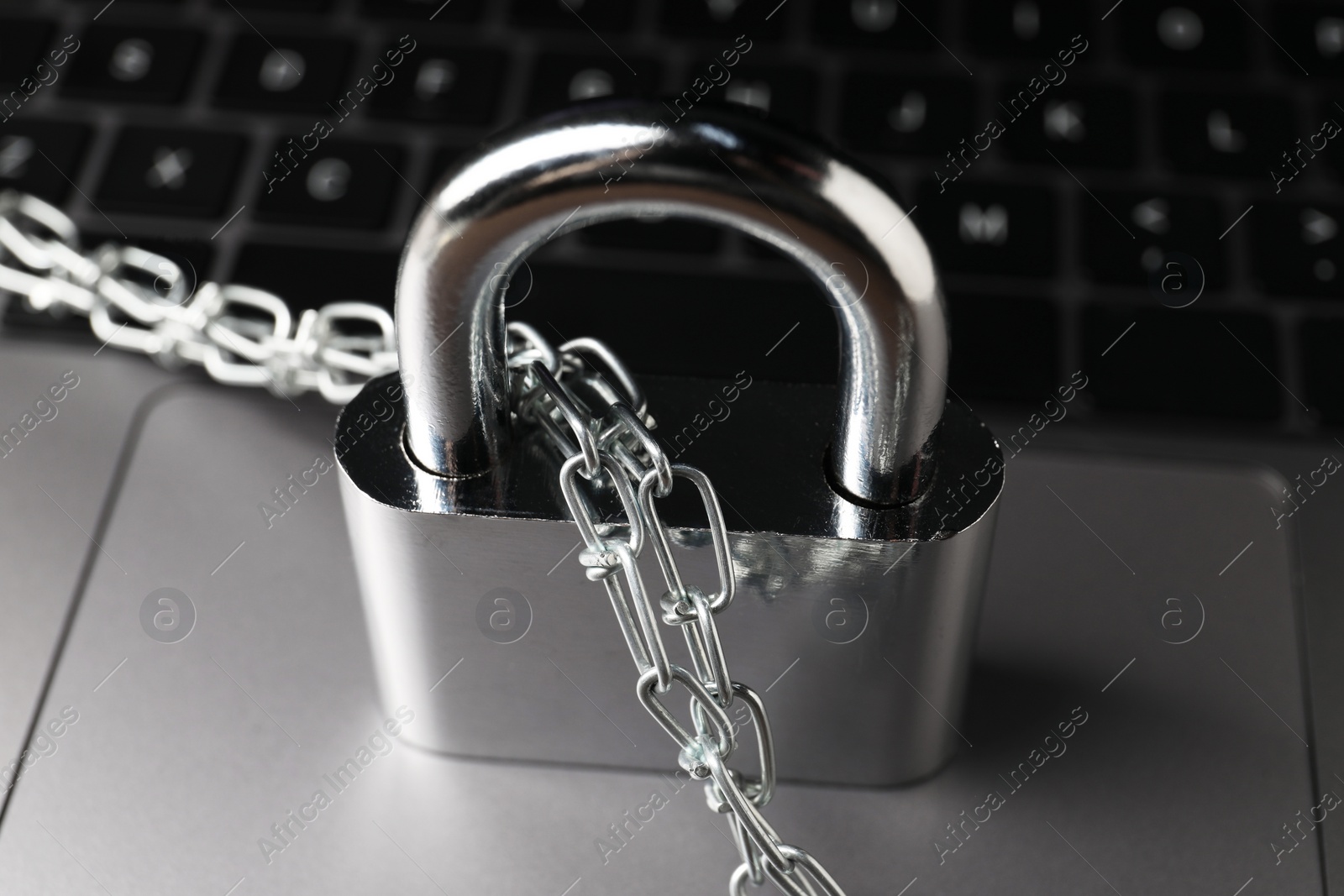 Photo of Cyber security. Padlock with chain on laptop, closeup