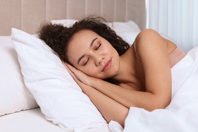 Beautiful African American woman sleeping in bed at home