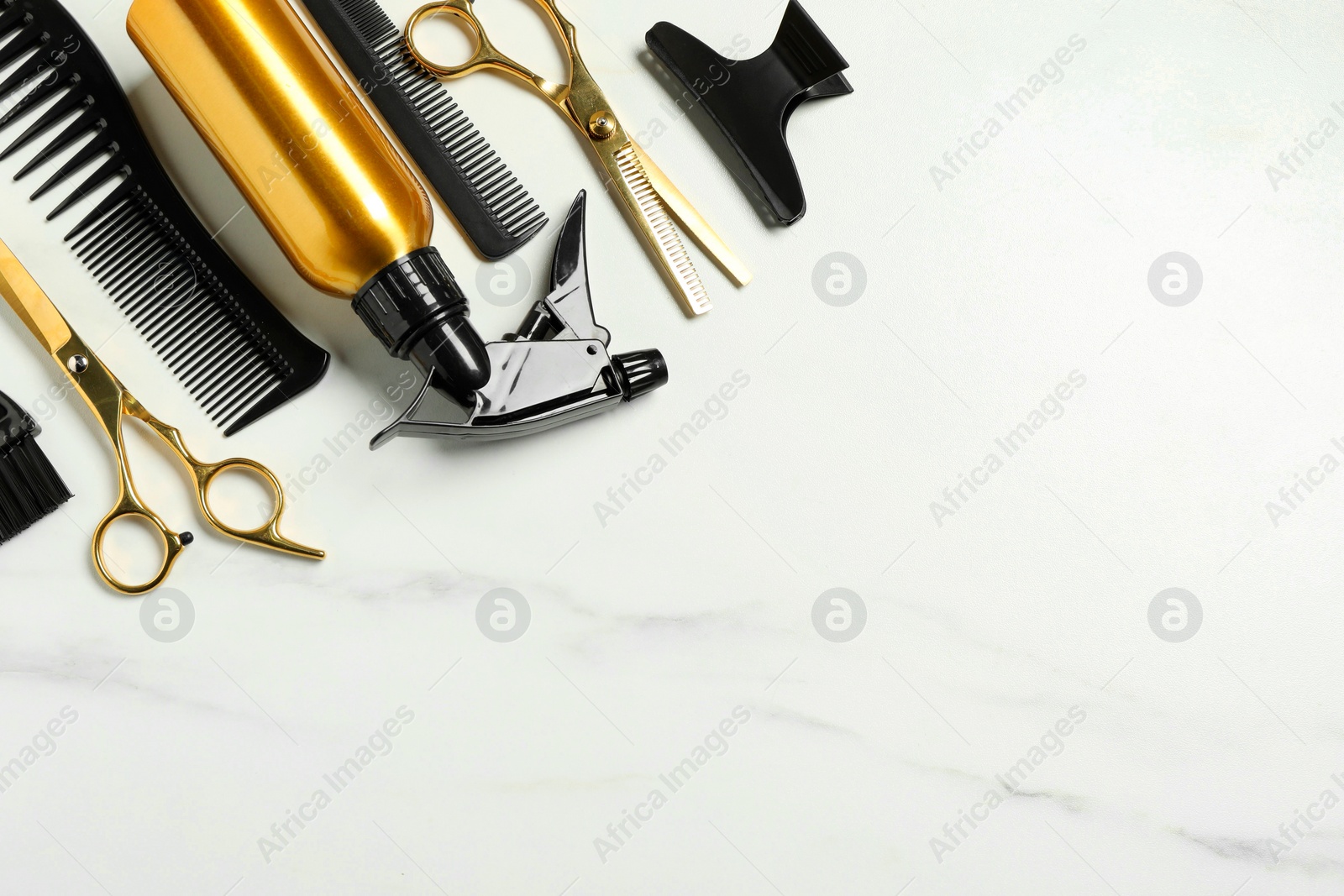 Photo of Hairdressing tools on white marble table, flat lay. Space for text