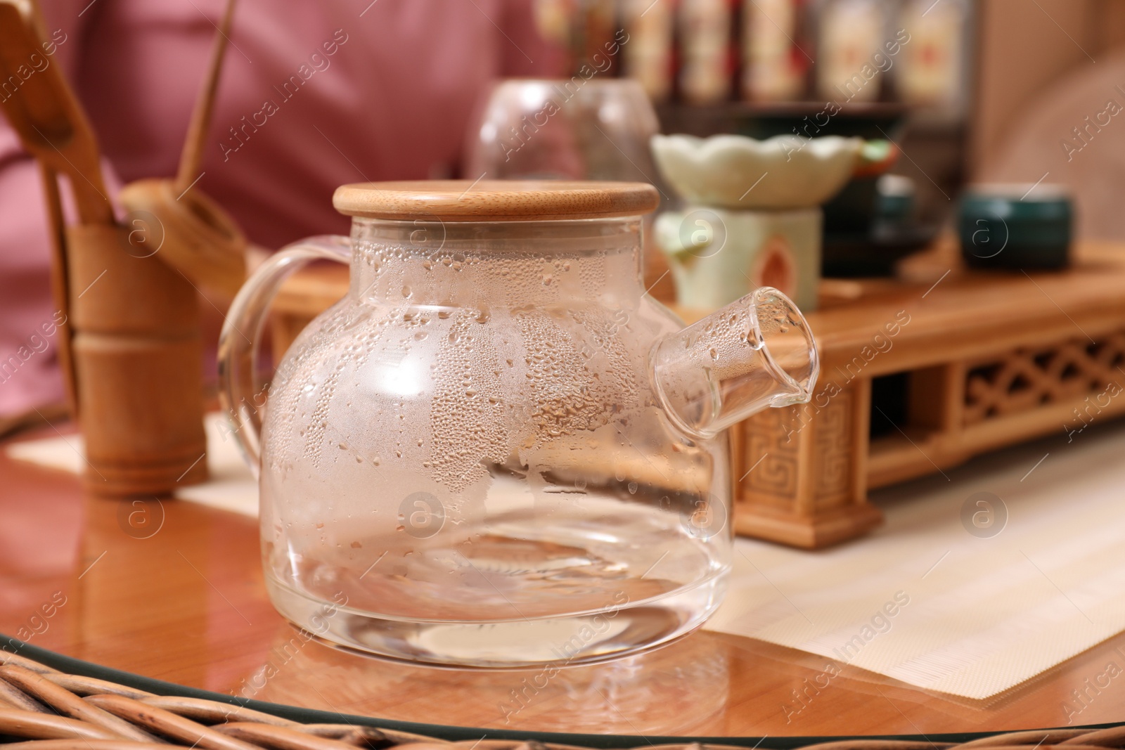 Photo of Glass pot for traditional tea ceremony on table indoors