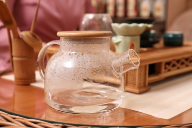 Glass pot for traditional tea ceremony on table indoors