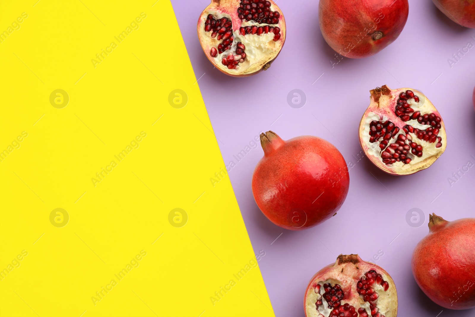 Photo of Flat lay composition with ripe pomegranates on color background. Space for text