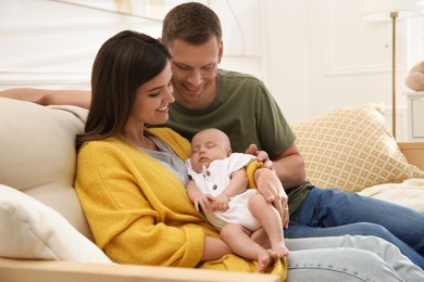 Photo of Happy couple holding their sleeping baby at home