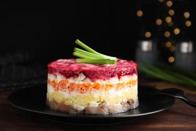 Herring under fur coat served on wooden table, closeup. Traditional russian salad