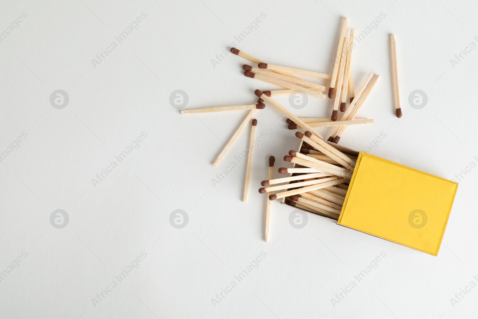 Photo of Cardboard box and matches on light background, top view. Space for design