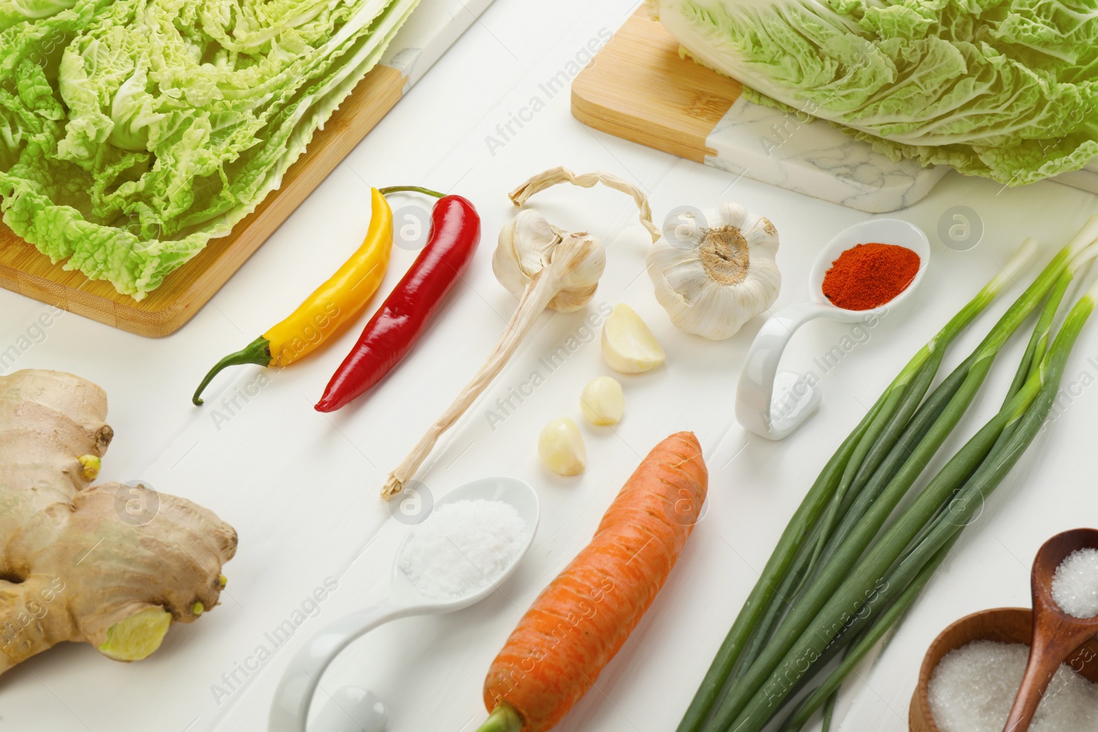 Photo of Composition with fresh Chinese cabbages and ingredients on white wooden table