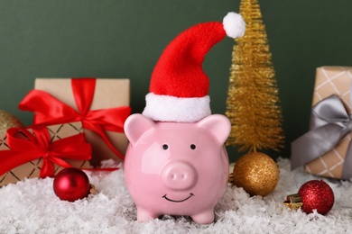 Photo of Composition with piggy bank and Christmas decor on color background