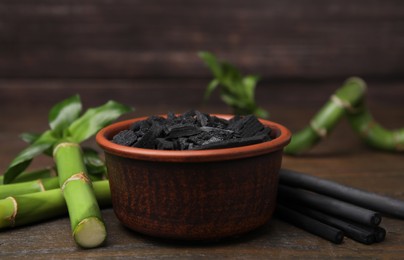 Fresh bamboo and charcoal on wooden table, closeup