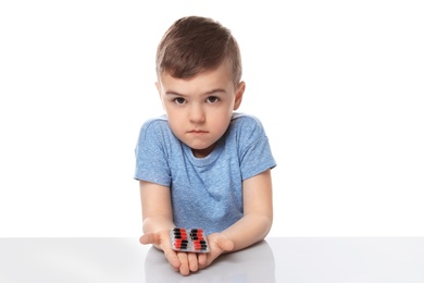 Photo of Little child with pills on white background. Household danger