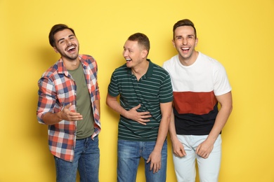 Group of friends laughing together against color background