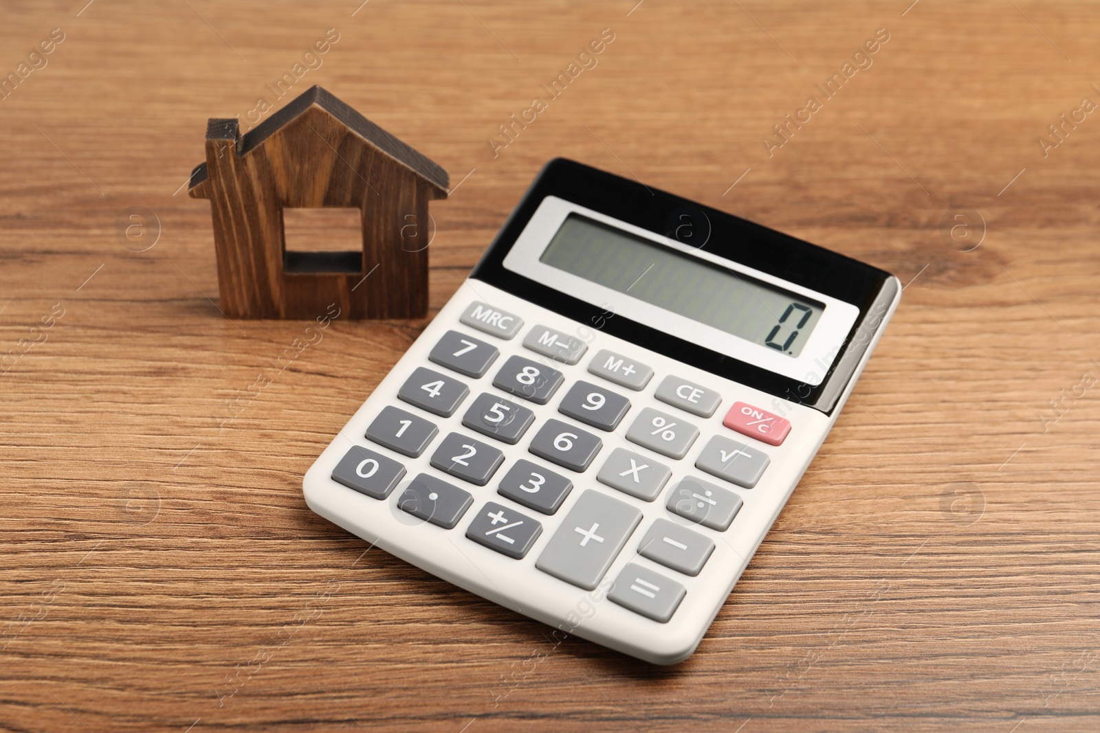 Photo of Mortgage concept. House model and calculator on wooden table