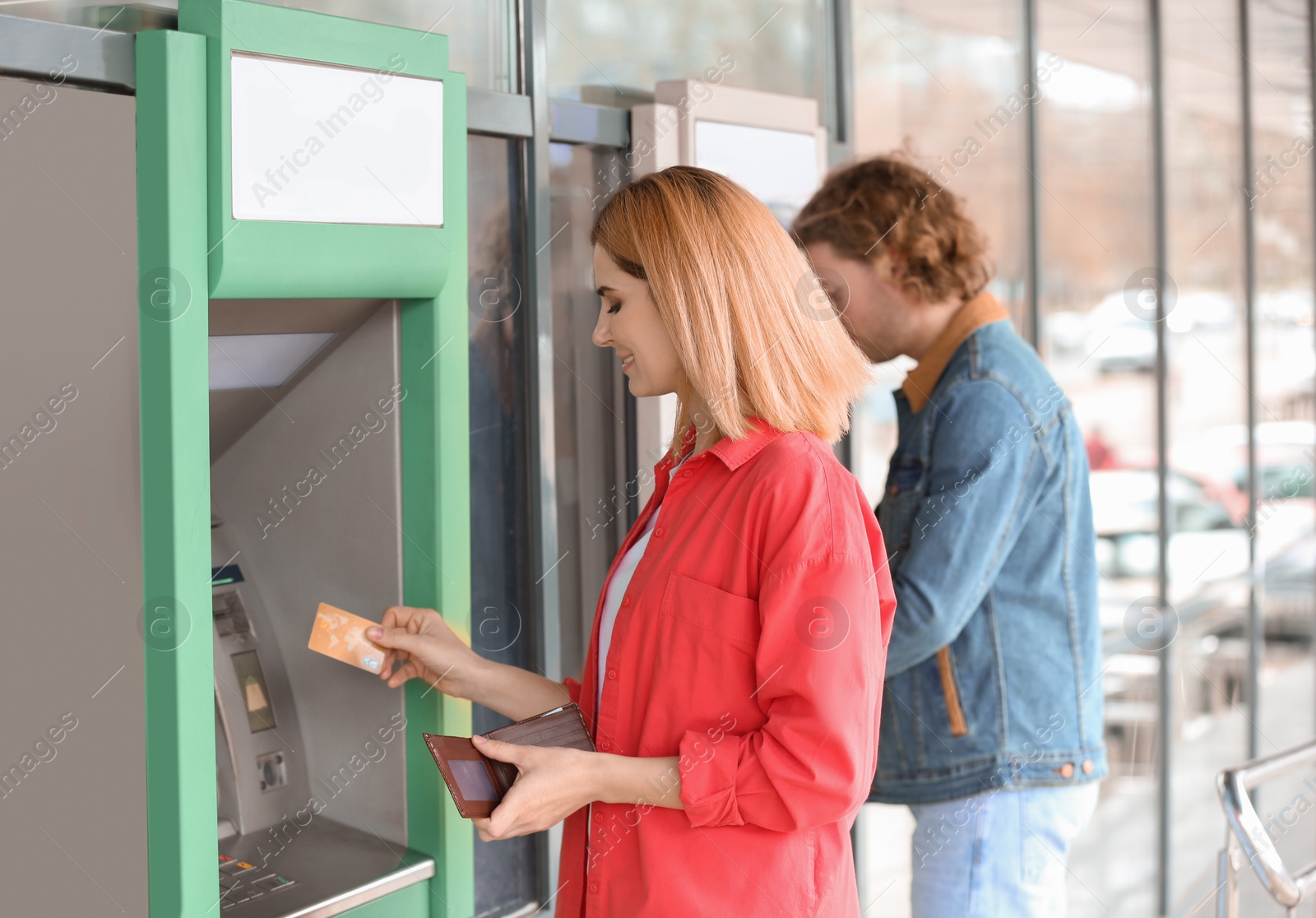 Photo of Beautiful woman with credit card near cash machine outdoors