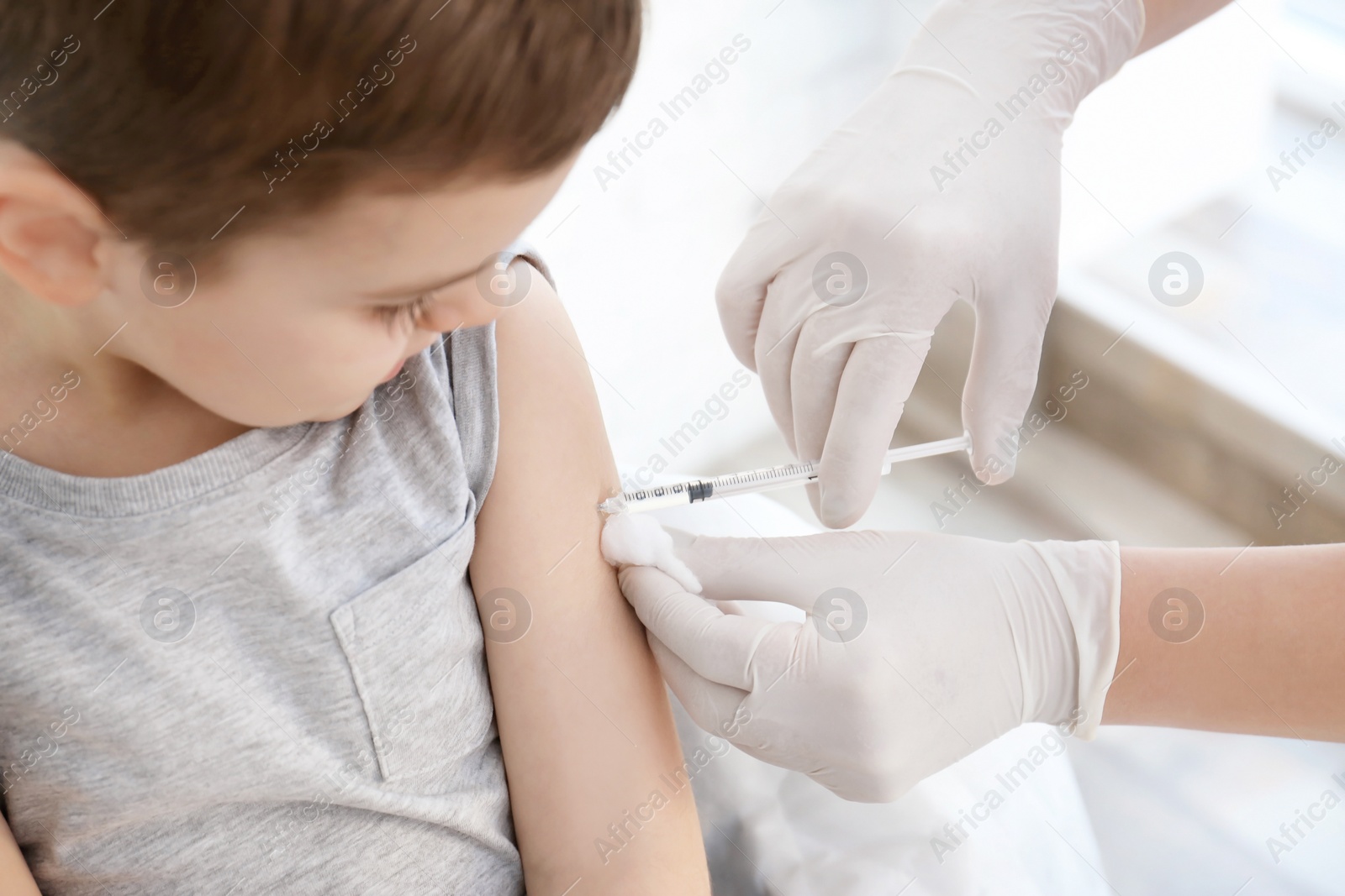 Photo of Doctor vaccinating little boy in hospital