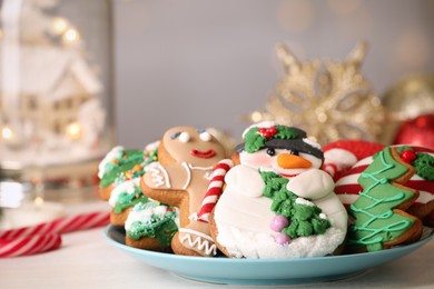 Photo of Sweet Christmas cookies on white table against blurred festive lights, closeup