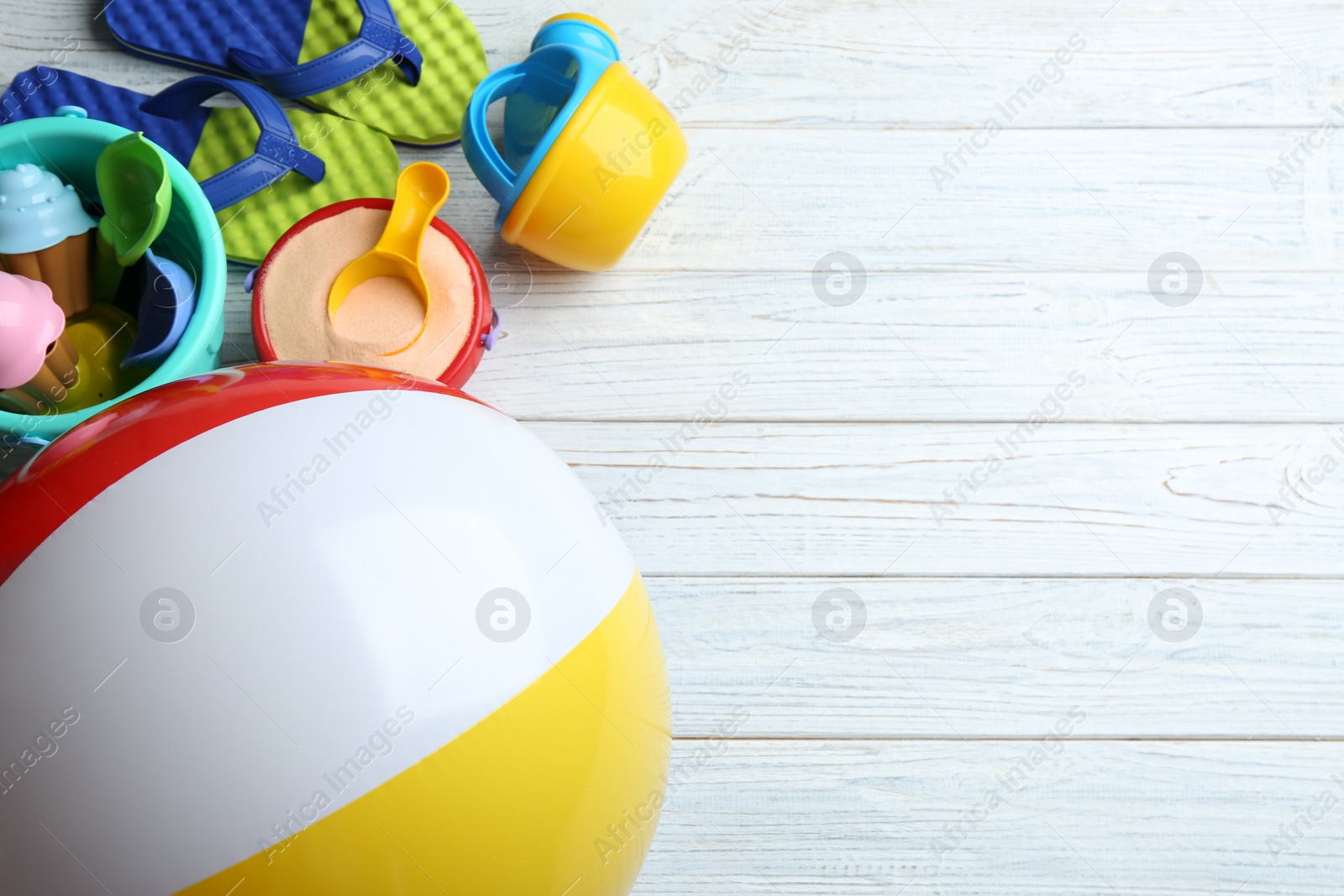 Photo of Flat lay composition with colorful beach toys on wooden background. Space for text