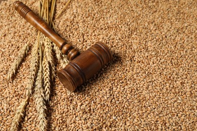 Wooden gavel and wheat ears on grains, closeup. Agricultural deal