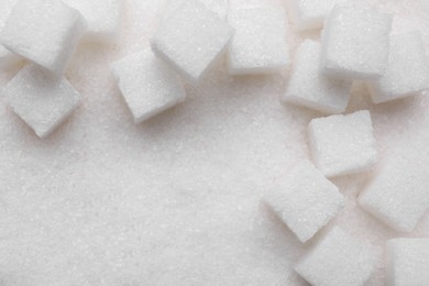 Different types of white sugar as background, top view