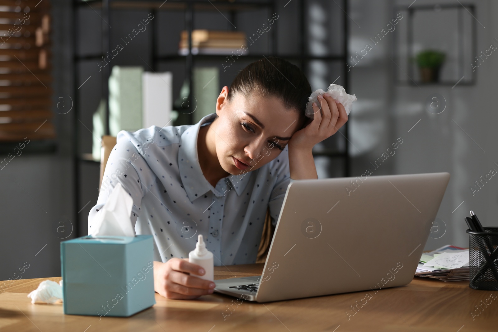 Photo of Ill businesswoman with nasal spray table in office