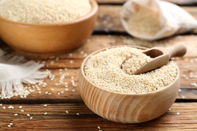 Photo of Bowl of white sesame seeds on wooden table