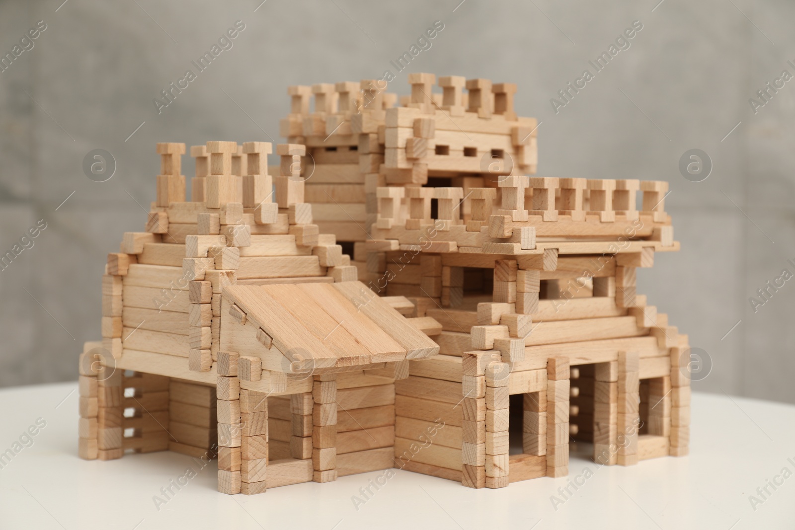 Photo of Wooden castle on white table. Children's toy