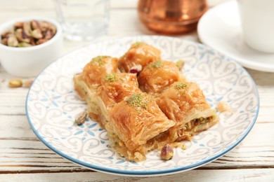 Photo of Delicious baklava with pistachios on white wooden table, closeup