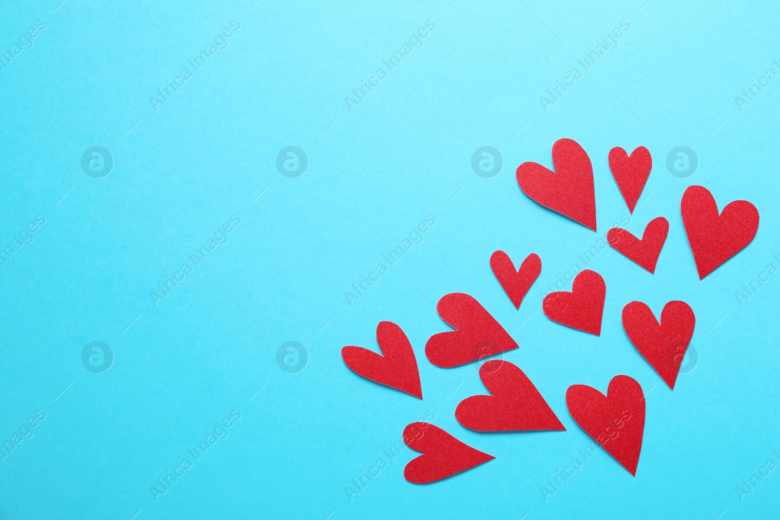 Photo of Red decorative hearts and space for text on light blue background, flat lay. Valentine's Day