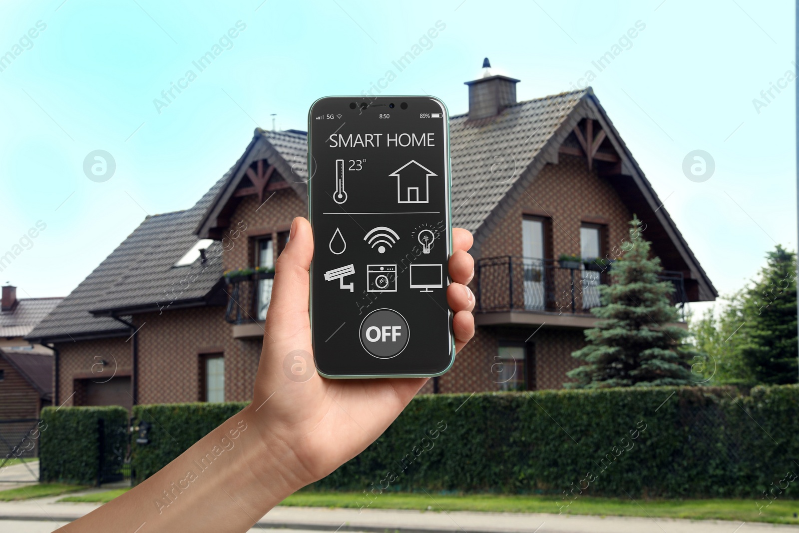 Image of Woman using smart home control system via mobile phone near house outdoors, closeup