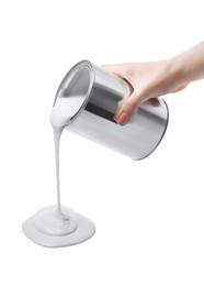 Photo of Woman pouring paint from can on white background, closeup
