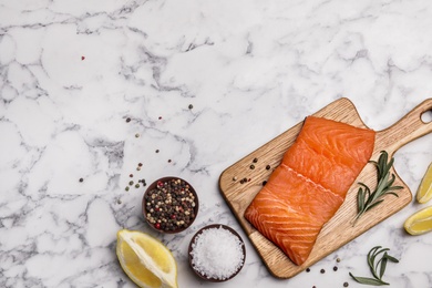 Photo of Flat lay composition with salmon fillet on marble table. Space for text