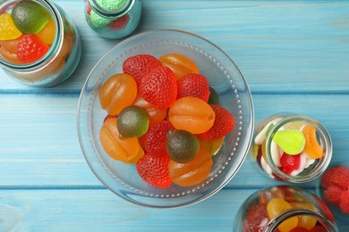 Photo of Delicious gummy candies on light blue wooden table, flat lay