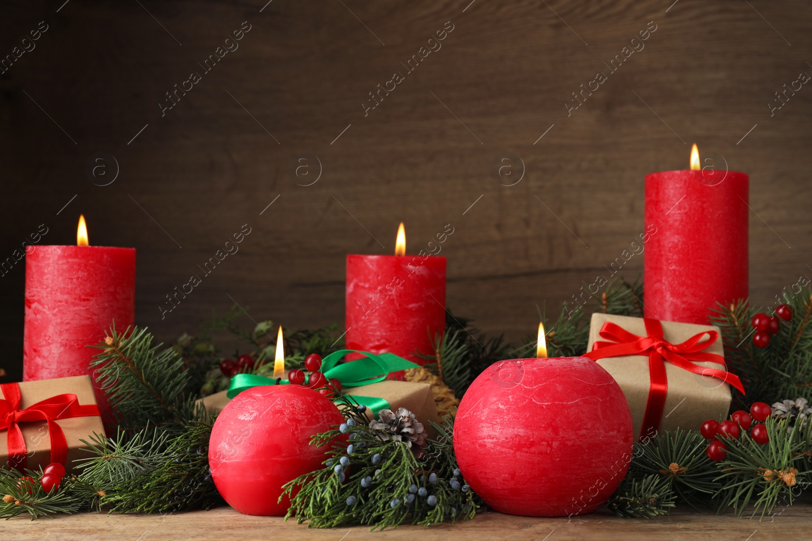 Photo of Beautiful Christmas composition with burning red candles on wooden background