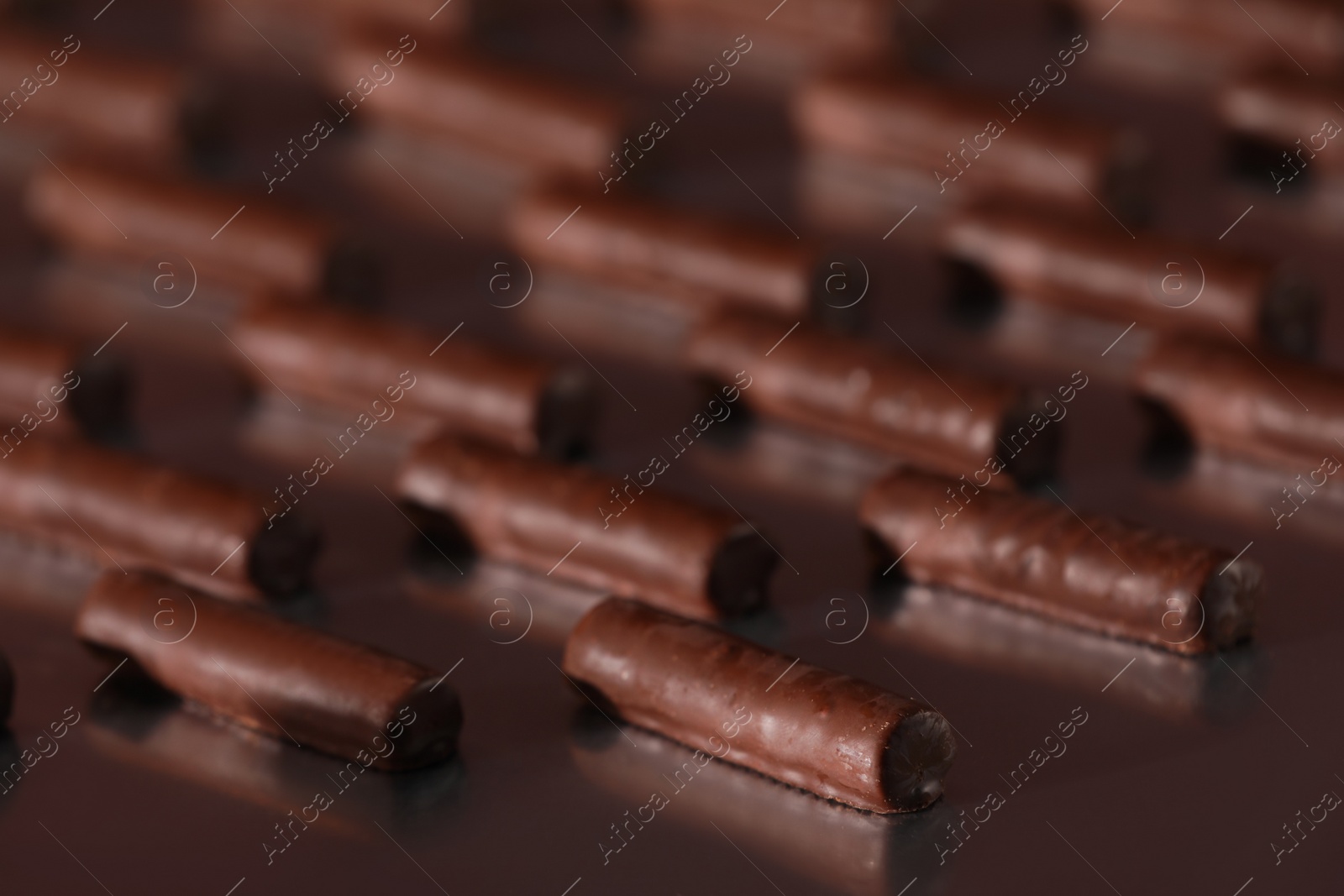 Photo of Many delicious chocolate candies on table, closeup. Production line