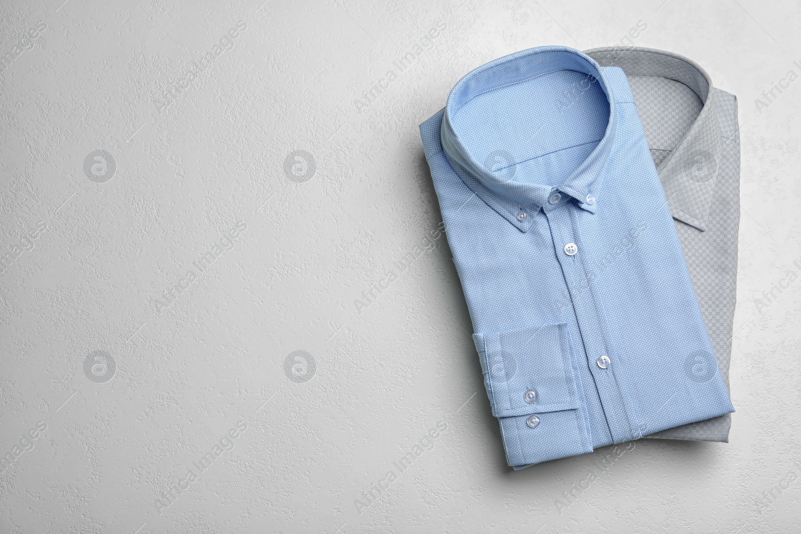 Photo of Stylish male shirts on white background, flat lay. Space for text