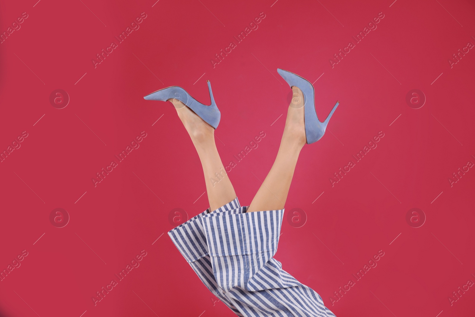 Photo of Woman in elegant shoes on crimson background