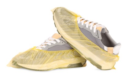Photo of Men's sneakers in yellow shoe covers isolated on white